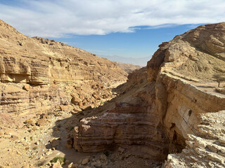 Canyon in the Eilat Mountains with layered sedimentary cliffs and dramatic sky