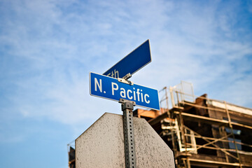 Obraz premium North Pacific street sign at an intersection in Sunset Beach, California, photographed from a low angle with blue sky, urban details, and coastal character.