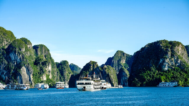 Cruise ships navigate the karst landscape of Ha Long Bay, Vietnam