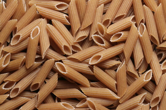 Penne pastas whole-grain close up studio shot over