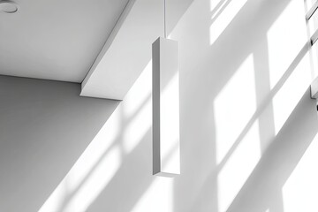 Geometric light fixture hangs in sunlit interior with stark shadows