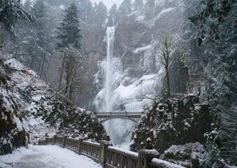 Snowy cascade plunges past iced-over pathway and arched bridge in tranquil forest