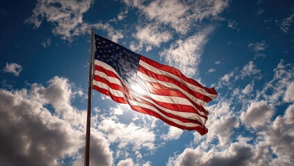 Waving national flag illuminated by sunlight against a dramatic cloudy sky