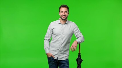 Smiling man with an umbrella standing against a green screen background, ready for any weather.