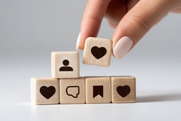 Hand placing a wooden block with a heart icon on top of a stack of blocks