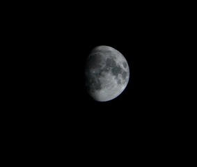 Naklejka premium A detailed close-up view of the moon showcasing craters and surface texture against a dark night sky