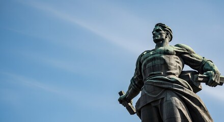 Fototapeta premium Dramatic low angle closeup of a heroic bronze statue against blu