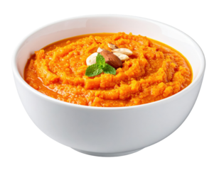 Creamy Carrot Soup Garnished with Nuts and Fresh Mint in a White Bowl