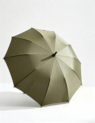 Minimalist Arrangement of a Simple Green Umbrella on a Soft White Background for Lifestyle Imagery and Social Media Usage