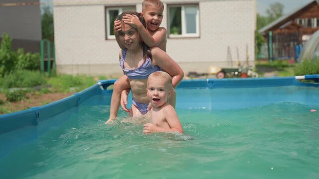 Youngsters Have Fun In Warm Outdoor Pool, Children Giggling And Splashing In Backyard Swimming Activity, Multiple Kids Sharing Joyful Moments During Summer Poolside Play In Sunny Yard