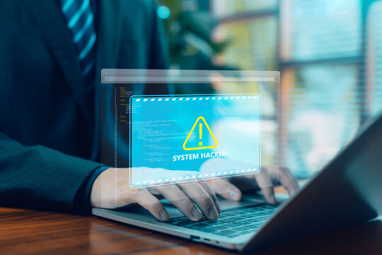 Businessman typing on laptop with system hacked warning alert on virtual screen, representing cybersecurity threat, data breach, malware attack, and online security risk in modern digital business. - Powered by Adobe