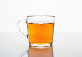 A clear glass mug filled with amber colored liquid isolated on white background