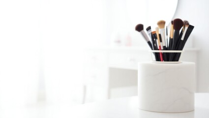 Collection of makeup brushes in a white holder on a white surface