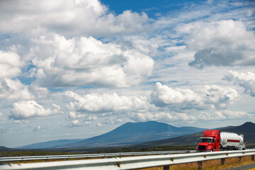 Red semi-truck on highway with mountain backdrop between Guadalajara and Morelia (Mexico)