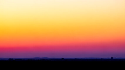 Fototapeta premium Colorful sunset sky over silhouette of landscape