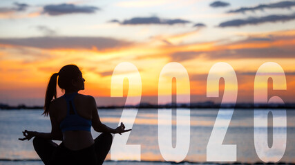 Happy new year card 2026. Silhouette lifestyle woman yoga practicing yoga standing as part of Number 2026 near the beach at sunset. Healthy and Holiday Concept
