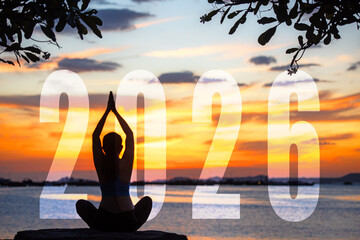 Happy new year card 2026. Silhouette lifestyle woman yoga practicing yoga standing as part of Number 2026 near the beach at sunset. Healthy and Holiday Concept