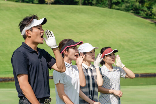 Male and female golfers cheering at the golf course