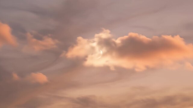A beautiful, ethereal scene captures a delicate crescent moon gently moving amidst a sky painted with soft, warm hues of pink, orange, and subtle purple. Wispy, atmospheric clouds drift lazily, occasi