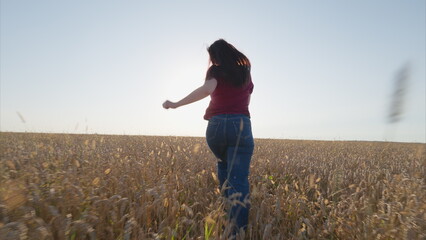 A woman joyfully embracing freedom while running gracefully in a sunlit field of wildflowers © beholdereye