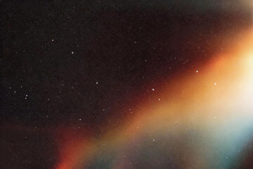 Obraz premium Abstract gradient light streak in orange, red and teal against dark starry background, subtle film grain texture, dreamy atmospheric style, soft diffused lighting, ethereal mood.