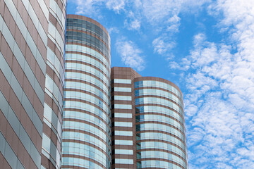 Landscapes building window glass top with sky blue white clouds and bright sunlight is background. Large building structure in business district in big city. Architecture of construction. Copy space.