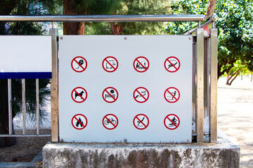 Sign symbol icon prohibit of No kite flying, fishing, swimming, animal husbandry, volleyball, tennis, skiing, fire making, cycling, surfing, diving, electric scooter, roller blades on stone platform.