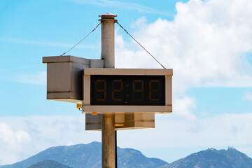 Digital Signs symbol LED electric Thermometer marking show red number 33 degrees celsius. By with sky and white clouds background. Air temperature.