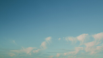 A Clear Blue Sky filled with Soft, Fluffy Clouds that enhance the beauty of the day