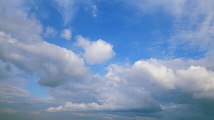 Fototapeta premium A beautiful blue sky adorned with fluffy clouds creates a picturesque and serene atmosphere