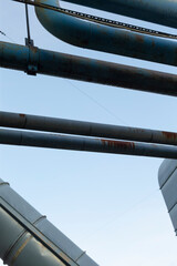 Naklejka premium Structural pipes against cloudy sky, Repeated metal elements shape architectural art, Industrial metal constructions with intersecting pipes form intricate architectural visual compositions