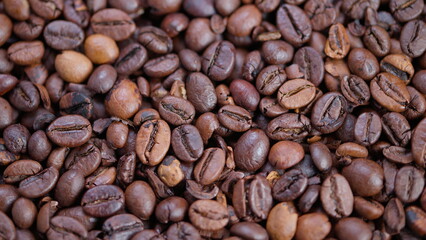 Fototapeta premium Highdefinition image focusing on shiny roasted coffee beans with detailed surface, Macro photograph capturing textured roasted coffee beans with oily sheen and warm lighting