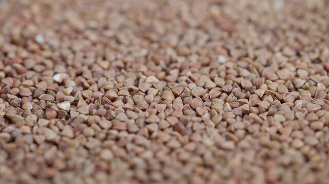 Buckwheat closeup view, Detailed buckwheat grain photograph, Zoomedin shot of buckwheat kernels texture, Macro image emphasizing buckwheat grains and earthy tones