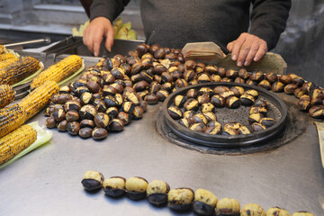 Street vendor sells roasted chestnuts in a busy market in istanbul 