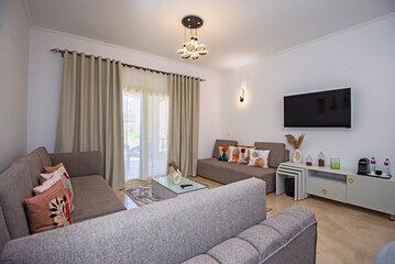 Living room lounge area in luxury apartment show home showing interior design decor furnishing with balcony terrace