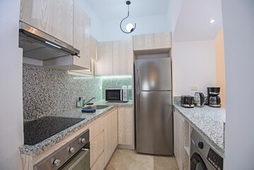 Kitchen area in small luxury apartment show home showing open plan interior design decor furnishing and appliances