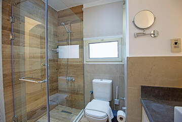 Interior design of a luxury show home bathroom with glass shower cubicle and toilet