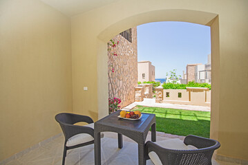 Terrace furniture of a luxury apartment in tropical resort with furniture and sea view over garden from balcony