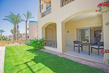 Terrace furniture of a luxury apartment in tropical resort with furniture and sea view over garden from balcony