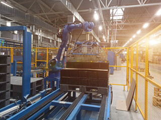 A robotic arm in a lead-acid battery production plant. flare, beam