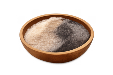 White and black salt forming a balanced yin yang symbol in a wooden bowl for seasoning, isolated