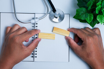 Self Care and Wellness Awareness Concept with hand holding Wooden Block, Stethoscope, and Copy Space