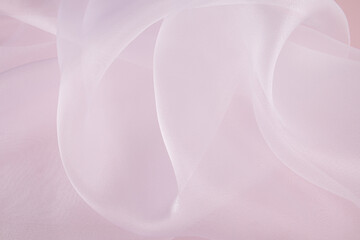 Chic large air waves of white organza on a pink background. stylish wedding background. light airy silk. shine of the fabric.