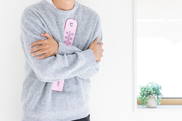 大きな温度計を持つ男性（日本人、顔無し、30代）_冬