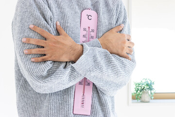 大きな温度計を持つ男性（日本人、顔無し、30代）_冬