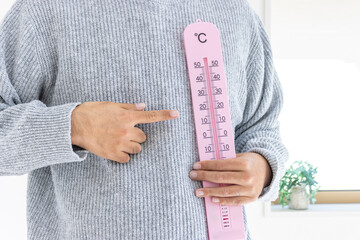 大きな温度計を持つ男性（日本人、顔無し、30代）_冬