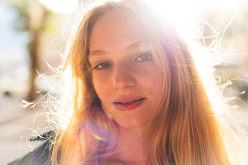 Close-up portrait of a young blonde on a sunny day. Cheerful smiling young woman on the street. Beautiful and cute blonde smiling.