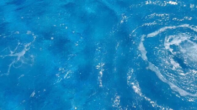 P54-Abstract water background of blue water waves and splashes with light reflections. Calm water textur 4K 10s