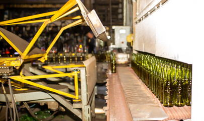 Glass factory, production of glass containers. Molten glass is blown into molds. Robotics in industry. Modern technologies, robotic machines produce products. Technological work at the plant.