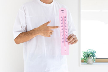 大きな温度計を持つ男性（日本人、顔無し、30代）_夏